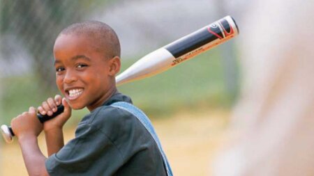 boy with baseball bat smiling