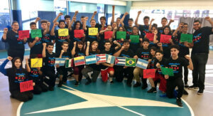 large group of Latinx youths raising up their fists and holding signs and flags of Latin America