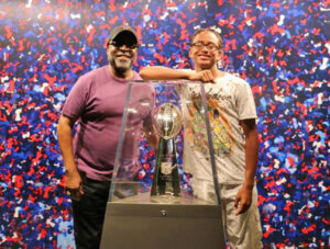 mentor and mentee standing next to super bowl trophy